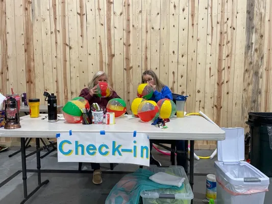 Two women running a check-in table with inflatable balls
